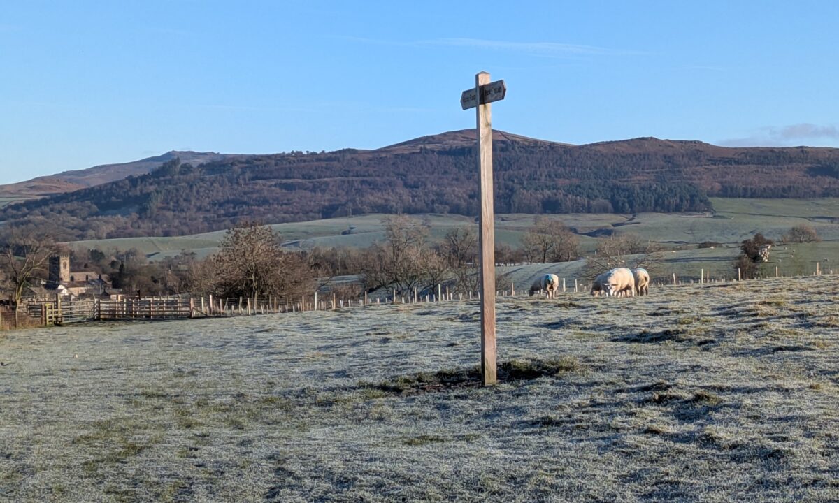 Pennine Way signpost to Gargrave with Sharp Haw in the background